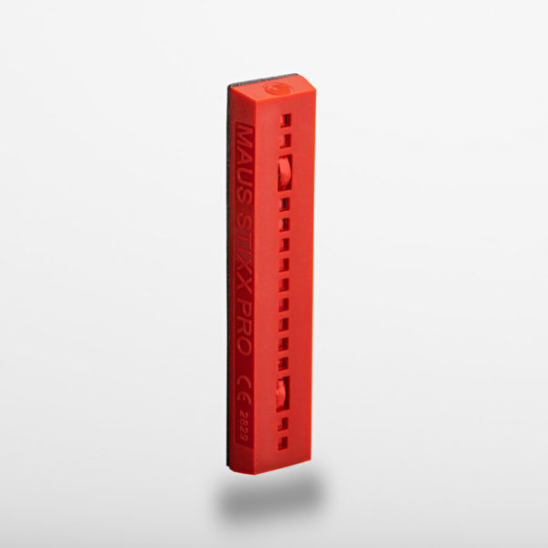 Red elongated stick with a black side and small sliders, seen from a slight top angle.