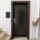 Deposit cabinet with dark brown frame and black door in entrance setting with plant decorations.