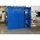 Blue storage cabinet with one open door showing binders, drills, and a toolbox in a workshop environment.