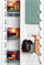 Adjustable light grey shelf inserts with ammunition, ear defenders and knife in a white cabinet, inner green compartment clos