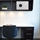 White valuables cabinet with digital code lock, positioned in office setting on wall above desk.