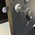 Close-up of a chrome-plated cylinder lock with a black key inserted into a black cabinet door, with an extended silver lockin