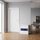 White safe with blue panel, key lock and key inserted, door closed, in an office environment on a parquet floor.